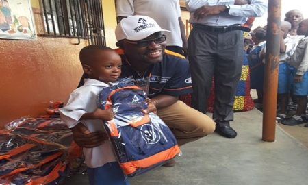 Sovereign Trust Insurance Plc, Segun Bankole poses with one of the Nursery Section recipients of school bags and exercise books